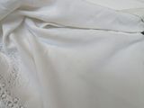 a white bed with a white comforter and a white pillow