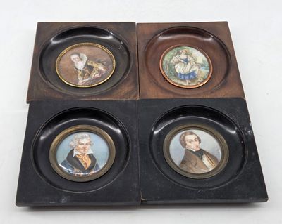 four miniature portraits of people in a wooden box on a white surface