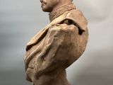 bust of a man with a collared shirt on a gray background