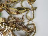 a pile of gold and silver jewelry on a white surface