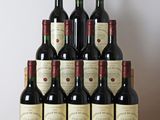 des bouteilles de vin rouge sont posées sur une table en bois devant un mur blanc