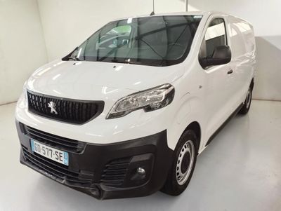 La petite camionnette blanche est garée dans une pièce blanche.