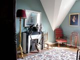 une photo d'une chambre avec une cheminée et un fauteuil