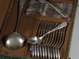 des couverts dans un étui vert contenant des cuillères, des fourchettes et des cuillères-fourchettes
