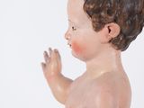 a figurine of a baby holding a blue ball