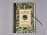 an old book with a green cover sitting on top of a table