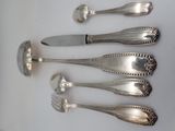 five silver spoons and a knife on a table