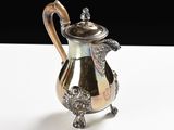 a silver tea pot sitting on a white table