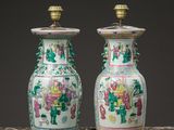 pair of chinese vases on a table with a black background