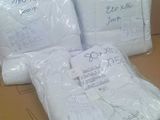 three bags of white towels sitting on top of a cardboard box