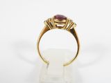 a close up of a gold ring with a ruby stone