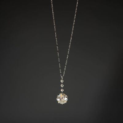 a white gold and diamond pendant on a black background