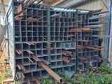 an image of a pile of metal pipes sitting on top of a dirt field