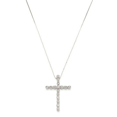 un pendentif en forme de croix en diamant, suspendu à une chaîne, sur fond blanc