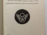 an open book with a black and white image of a military emblem