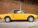 a yellow car parked in front of a brick wall