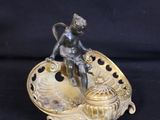 an antique bronze figurine of a boy on a shell