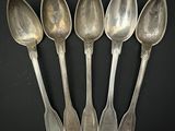 six cuillères en argent sont alignées sur une surface noire