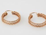 a pair of gold hoop earrings on a white background
