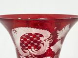 a red vase with a design on it on a table