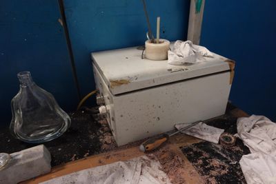 une photo d'une salle de bains sale avec beaucoup de désordre par terre