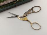 a pair of scissors sitting on a table next to a case