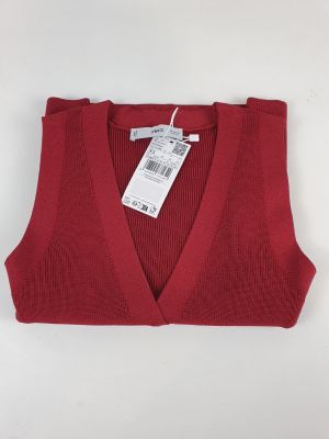 Le pull est rouge et porte une étiquette blanche.