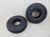two black tires are sitting next to each other on a white surface