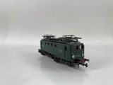 the green train is on the tracks on a white surface
