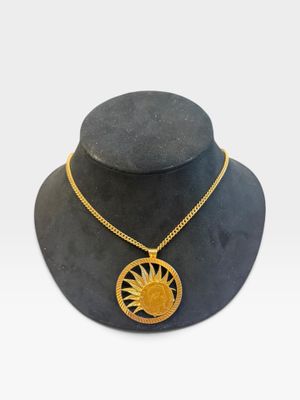 un mannequin noir orné d'un pendentif en forme de soleil doré