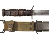 an old knife with a metal handle and a canvas sheath