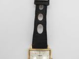 l'image d'une montre en or avec un bracelet en cuir noir