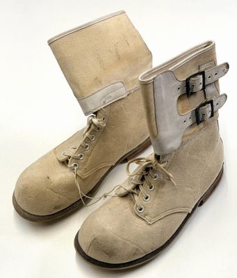 une paire de bottes beiges à boucles sur fond blanc