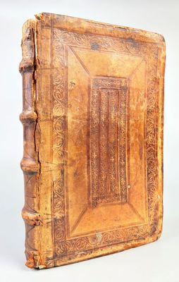 un vieux livre à la couverture en bois posé sur une table