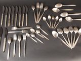 many forks and spoons laid out on a table