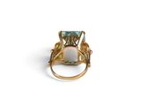 a close up of a ring with a green stone in it