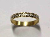 gros plan d'une bague en or avec des diamants sur une surface blanche