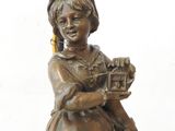 bronze statue of a woman holding a bird and a birdcage