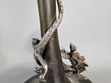 a silver vase with a snake on it on a table