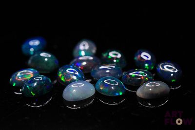 some very pretty blue and green oplite stones on a black surface