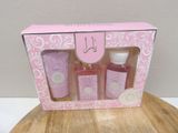 a pink box with three bottles of soap and a bottle of lotion in it