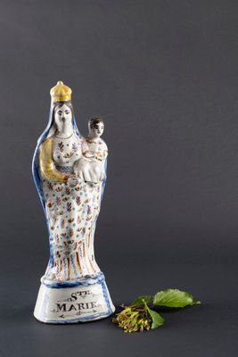 une figurine représentant une femme tenant un bébé et un chat dans ses bras