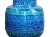 a blue vase that is sitting on a white surface