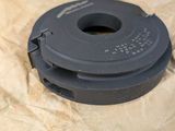 an image of a black plastic spool on a piece of paper