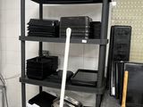a black shelving in the kitchen with a mop next to it