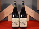 two bottles of wine sitting next to each other on a table