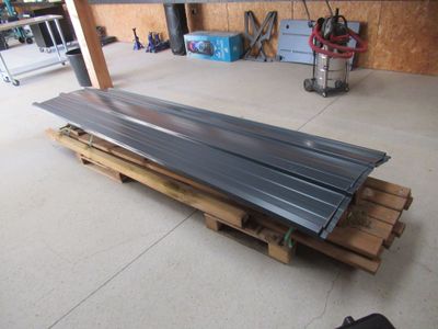 un tas de tôles posées sur une palette dans un garage