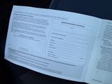 a paper document with information on it in the back seat of a car
