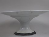 a white bowl with a black rim on a white table