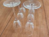 four empty wine glasses sitting on top of a wooden table